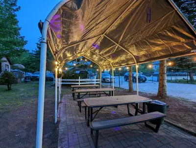 a group of picnic tables under a tent at Modern Tiny Wood Cottage #2 in Wasaga Beach