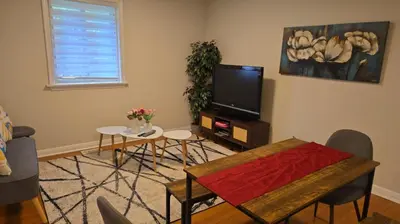 a living room with a tv and a table and chairs at \u9a6c\u5361\u59c6\u7684\u5bc4\u5bbf\u5bb6\u5ead- Simple Trip To Toronto in Markham