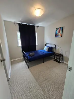 a bedroom with a blue couch in a room at \u9a6c\u5361\u59c6\u7684\u5bc4\u5bbf\u5bb6\u5ead- Simple Trip To Toronto in Markham