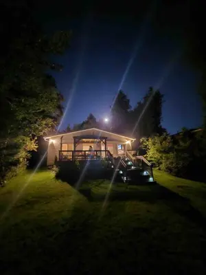 a house lit up at night with lights at Lovely Little Lake House in Brighton