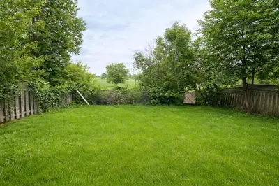 a yard with a fence and green grass at Newly Renovated 3BR Orangeville Basement Suite with Private Access, 10 Min Walk to Headwaters Hospital, 5 Min Drive to Mount Alverno! Ideal for Medical Stay, Family Travel & Work Trips! in Orangeville