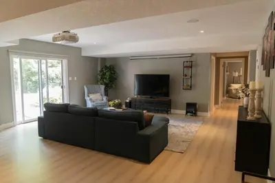 a living room with a couch and a flat screen tv at Cozy Private Suite with Year-Round Hot Tub in Elora