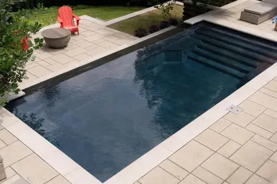 a swimming pool with a red chair in a yard at Cozy Private Suite with Year-Round Hot Tub in Elora