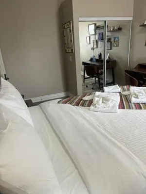 a large white bed in a room with a desk at Downtown Private Room Central Location in Toronto