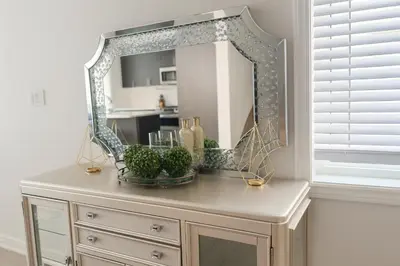 a mirror on top of a dresser in a room at 2024 Built Stylish 3BR Cambridge Townhouse with Free Parking, WiFi, Full Kitchen, Laundry, 8 Min Drive to African Lion Safari! Perfect for Family Travel, Group Trips & Work Stays! in Cambridge