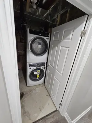 a washer and dryer sitting next to a door at Cozy 2 Bedroom Apartment in Brampton in Brampton
