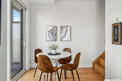 a dining room with a white table and chairs at Stunning 2BR Toronto Retreat, Patio & Parking in Toronto