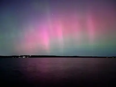 an aurora over a body of water at night at Rice Lake Retreat in Roseneath