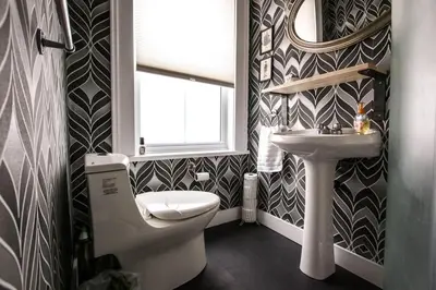 a bathroom with a toilet and a sink and a window at The County Queen - Historic Home in Picton in Picton