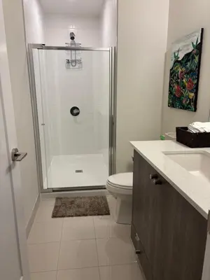 a bathroom with a shower and a toilet and a sink at Beautiful Quaint Home in Port Credit, Mississauga in Mississauga