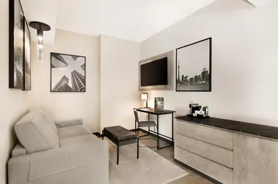 a living room with a couch and a tv at Riu Plaza Toronto in Toronto