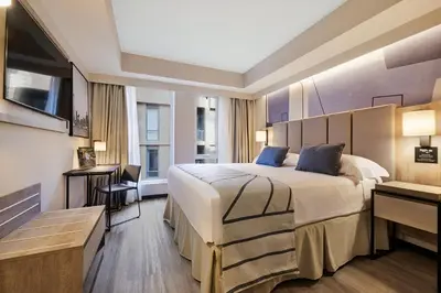 a hotel room with a large bed and a desk at Riu Plaza Toronto in Toronto