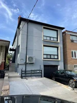 a building with a car parked in front of it at The Basics - Private Room in Toronto