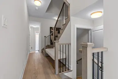 a staircase in a home with white walls and wood floors at Luxury Townhome in Oakville