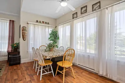 a dining room with a table and chairs and windows at The Sumac - 8 Natures in Cherry Valley