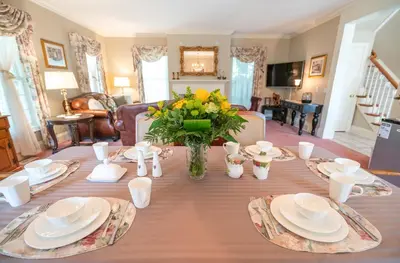 a dining room table with a vase of flowers on it at John & Gate House boutique Bed and Breakfast in Niagara on the Lake