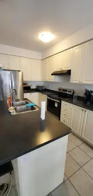 a kitchen with white cabinets and a black counter top at Stay 15 mins from Niagara Falls-5 Bedroom nights Inn in Thorold