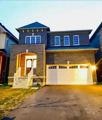 a house with two garage doors and a driveway at Stay 15 mins from Niagara Falls-5 Bedroom nights Inn in Thorold