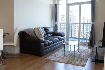 a living room with a leather couch and a table at Spacious 2 bedrooms 2 bathrooms with Cozy Charm plus 1 Parking in Mississauga