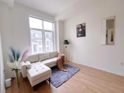 a living room with a white couch and a window at Modern entire house close to Costco convenient stay in Richmond Hill