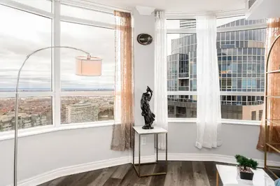 a room with large windows with a cat statue on a table at Sky Retreat | 2BR-2BA High Floor | 180° City View in Mississauga