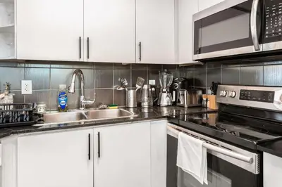 a kitchen with white cabinets and a sink at Sky Retreat | 2BR-2BA High Floor | 180° City View in Mississauga