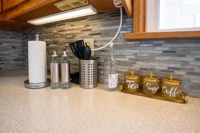a kitchen with a counter with bottles and utensils at Newly Renovated 3BR North York Bungalow with Backyard Patio & Volleyball Set! Close to Rogers Stadium, TTC Subway Access, Perfect for Family Travel, Group Trips & Work Stays! in Toronto