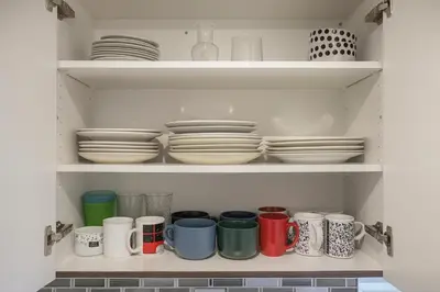 a cupboard filled with plates and cups and dishes at Cozy 3BR Caledon Basement Suite with Private Access, Full Kitchen, WiFi, Laundry, Backyard Basketball Court & Creek Trail, 5 Mins to Brampton! Great for Families & Long Stays! in Caledon