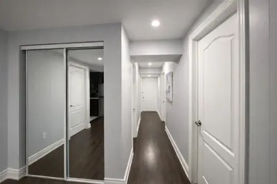 a hallway with a glass door and a mirror at Cozy 3BR Caledon Basement Suite with Private Access, Full Kitchen, WiFi, Laundry, Backyard Basketball Court & Creek Trail, 5 Mins to Brampton! Great for Families & Long Stays! in Caledon