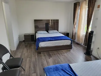 a bedroom with a bed with blue sheets and wooden floors at Luxury Suite - Master Bedroom in Niagara Falls