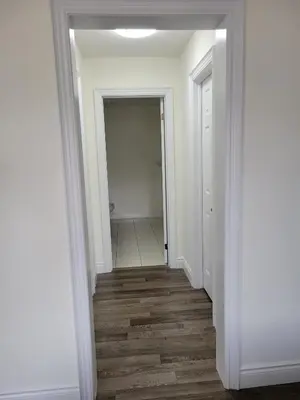 a hallway with white walls and wood floors at Luxury Suite - Master Bedroom in Niagara Falls