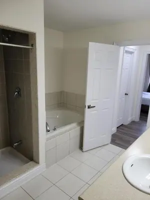 a bathroom with a tub and a toilet and a sink at Luxury Suite - Master Bedroom in Niagara Falls