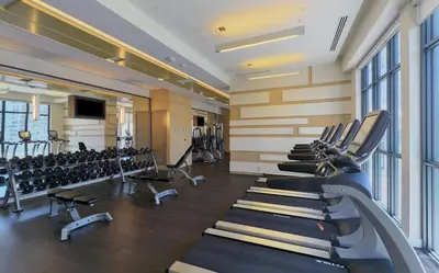 a gym with a row of treadmills and chairs at Luxury 1 BR and Den Near CN Tower in Toronto