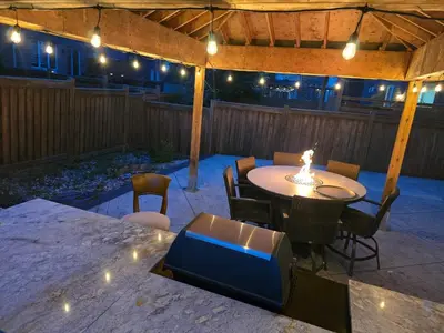 a patio with a table and chairs and lights at Your Luxurious Caledon Escape in Brampton