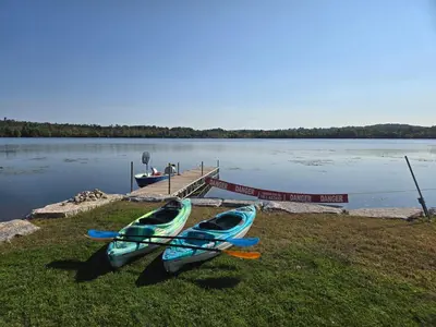 three kayaks are parked on the grass near a dock at Wheel chair Access, Private Boat Launch in Roseneath