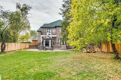 a large house with a fence and a yard at Elegant Home with Yard and Comforts in Richmond Hill