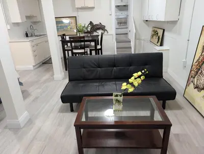 a living room with a black couch and a table at Cozy Bachelor Unit in Guelph