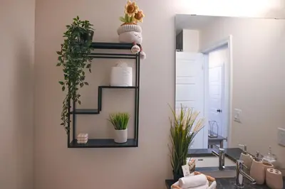a bathroom with a mirror and plants on the wall at Modern 3Bed Home 10 Mins to Niagra Falls in Thorold