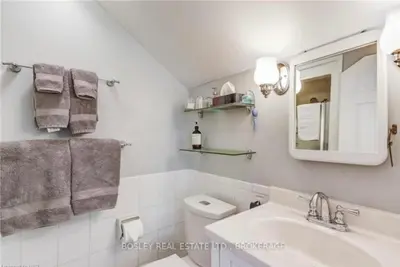 a bathroom with a sink and a toilet and a mirror at Matisse B&B in Niagara on the Lake