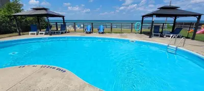 a large blue swimming pool with chairs and a gazebo at The Driftwood Deck 5B in Wasaga Beach