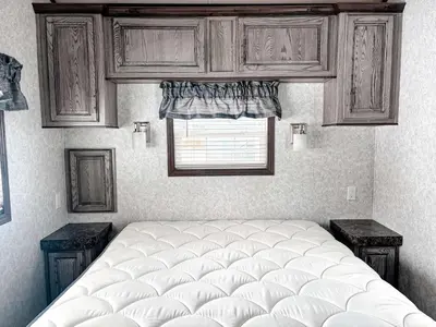 a bedroom with a large bed and a window at Bobcaygeon Shores Cottage Resort in Kawartha Lakes