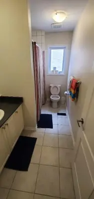 a bathroom with a toilet and a window at 15 mins from Niagara falls-5 Bedrooms Inn in Thorold
