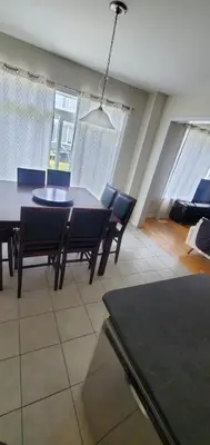a dining table and chairs in a living room at 15 mins from Niagara falls-5 Bedrooms Inn in Thorold