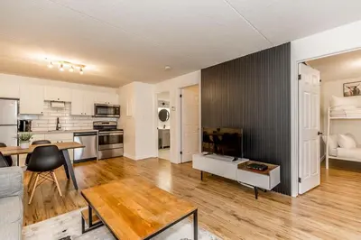 a living room with a table and a kitchen at The Landing Pad - Condo in Collingwood in Collingwood
