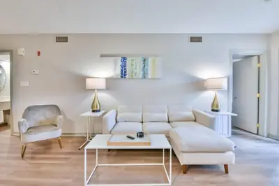 a living room with a white couch and a table at Highland Hideaway 1BR King Suite in Shanty Bay