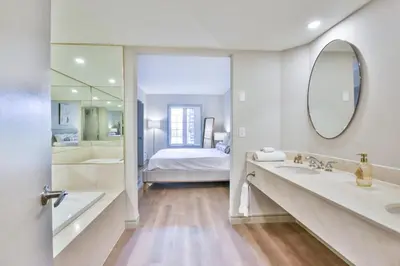 a bathroom with a tub and a sink and a mirror at King Suite heated Pool Sauna and Kitchen in Shanty Bay