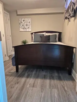 a bed in a bedroom with a wooden floor at Whitby one bedroom apartment in Whitby