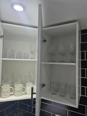a cupboard filled with wine glasses and dishes at Whitby one bedroom apartment in Whitby