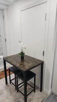 a black table with a vase of flowers on it at Entire Studio Guest Suite in Kitchener in Kitchener