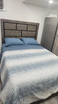 a bedroom with a bed with a black and white comforter at Entire Studio Guest Suite in Kitchener in Kitchener